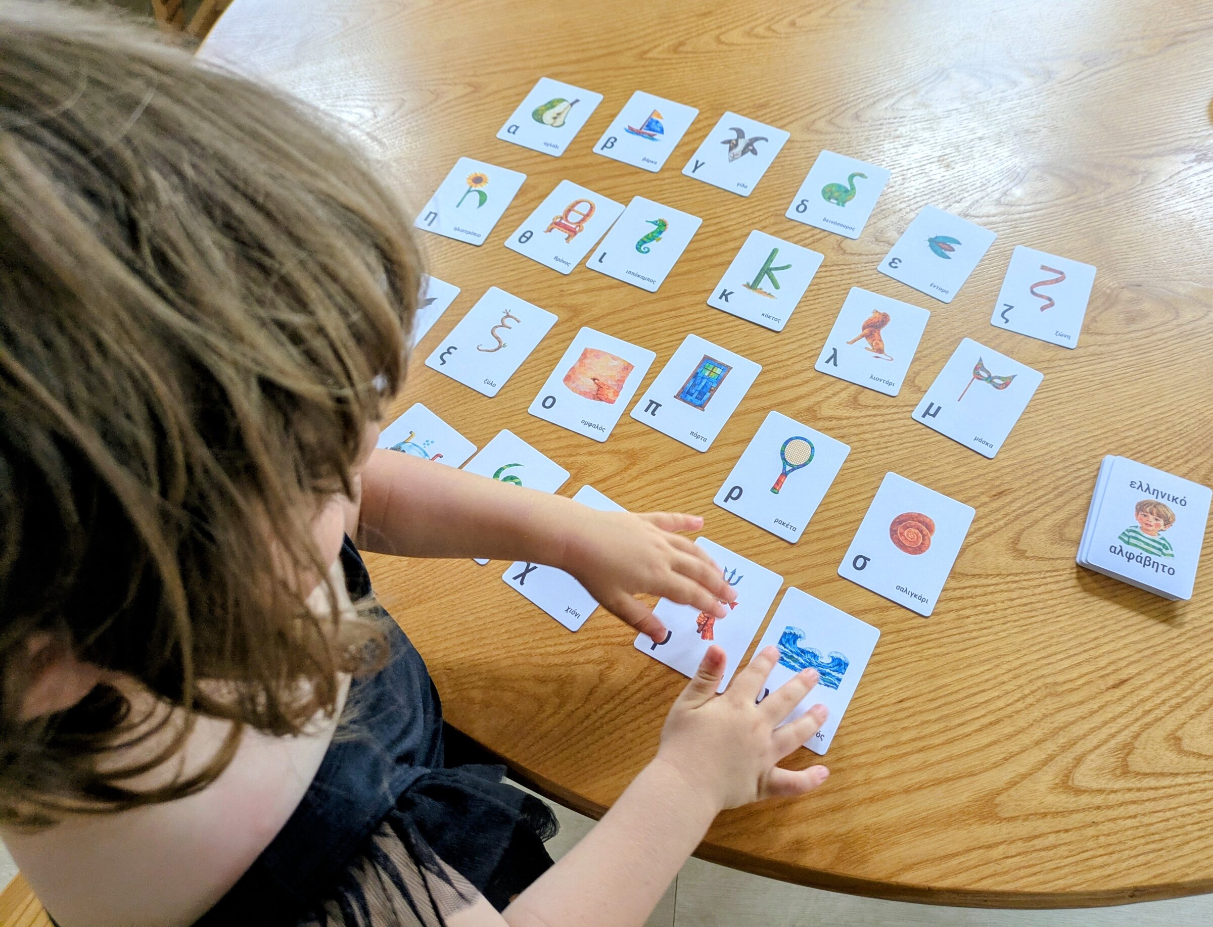 My daughter playing with the alphabet cards on a wooden table